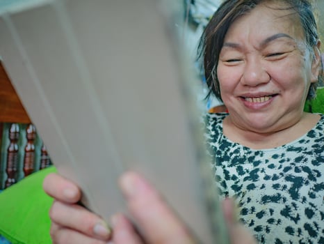 Very happy Old asian women Look at the tablet in her house photo