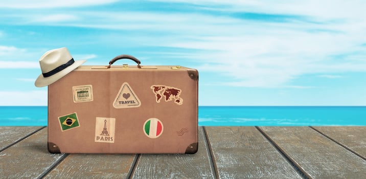 Old travel suitcase and white hat on wooden floor with sea and sky in background. Copy space beside. Tropical travel concept. photo