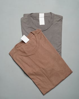 Stacks of plain cotton t-shirts neatly arranged. Plain colorful t-shirts, ready to be made into design mockups. T-shirts are clean without any branding. Men's blank T-shirt template. focus blur. eid photo