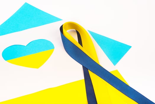 heart cut out of paper and painted in blue and yellow colors and ribbon of flag. Creativity as support of Ukraine photo