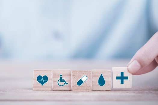 Hand chooses a emoticon icons healthcare medical symbol on wooden block , Healthcare and medical Insurance concept photo