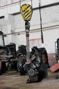 the tractor engine is suspended on a winch photo