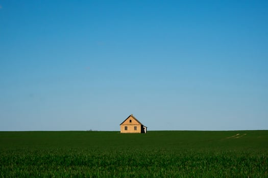 house on a green field and blue sky photo