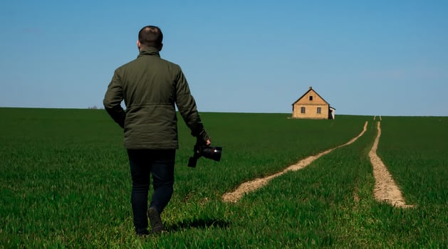 Photograph with a camera in hand walking down the road photo