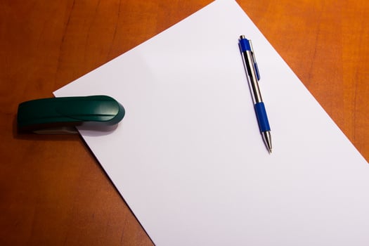 stapler and a sheet of paper photo
