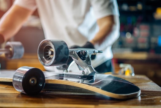 Skateboard and longboard on wooden desk in repair shop , Skateboard maintenance and repair concept. Selective focus on suspension set photo