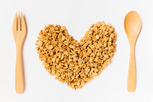 Close up of uncooked rolled oats shape form heart with wooden spoon and fork isolated on white background.  food ,Raw food ,Valentine day. photo