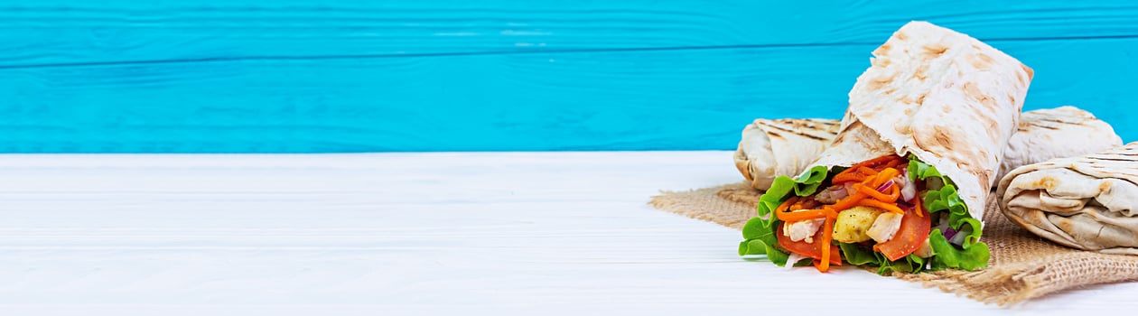 Delicious shawarma sandwich on wooden background. Banner. photo
