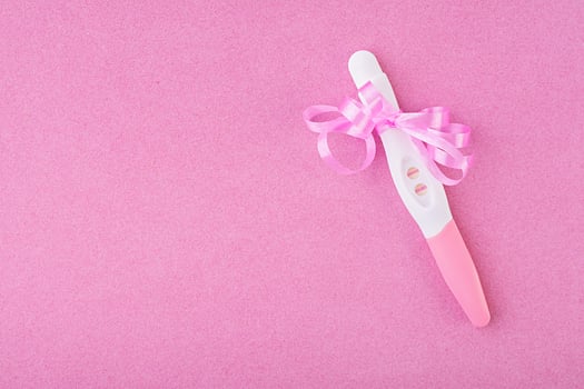 Positive pregnancy test isolated on pink background photo