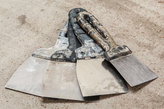 Dirty spatulas on cocnrete floor photo