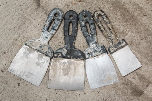 Dirty spatulas on cocnrete floor photo