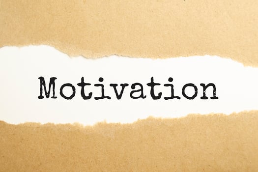 The text motivation appearing behind torn brown paper photo
