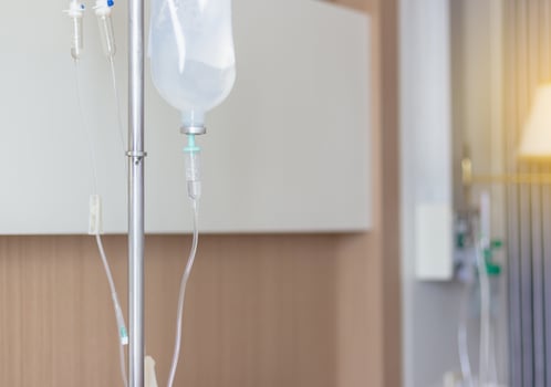 Saline solution drip set and bottle on a pole for patient and infusion pump in hospital photo