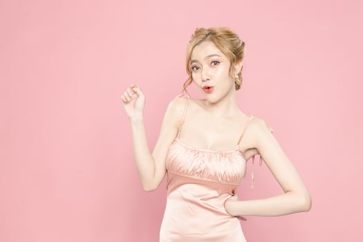 Portrait of pretty attractive excited asian woman model good mood hold showing novelty low price sale product shopping hand on isolated pink background. photo