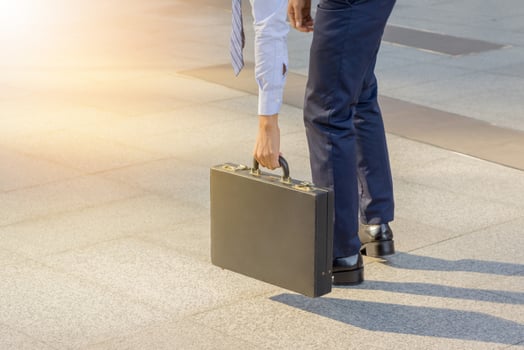 Businessman holding leather briefcase going to work photo