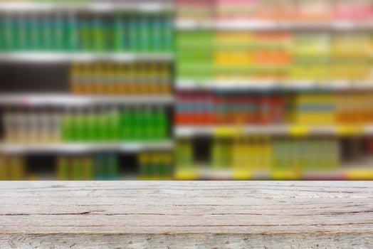 Empty table over blur view of beverage product on shelves in supermarket photo