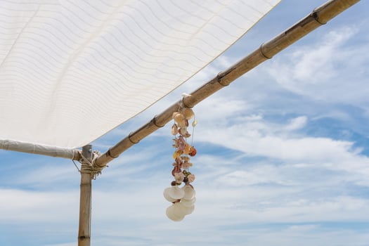 Seashell souvenir hanging decoration on wooden gazebo with tropical beach photo