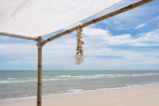 Seashell souvenir hanging decoration on gazebo with tropical beach photo
