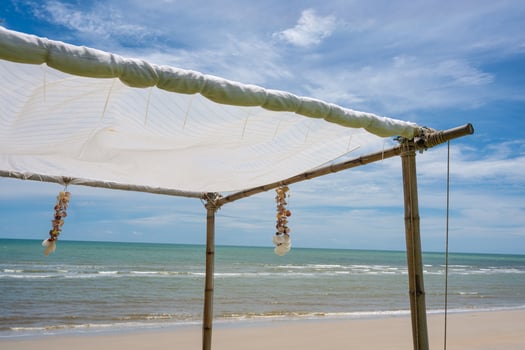 Seashell souvenir hanging decoration on wooden gazebo with tropical beach photo