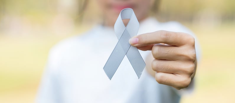 Brain Cancer Awareness month, woman hand holding grey color Ribbon for supporting people living. Healthcare and World cancer day concept photo