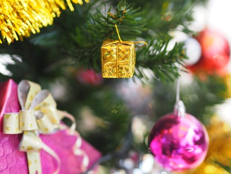 Decorated Christmas green tree decorations have Gift box gold red ball hanging pine, leaves on blurred of background photo