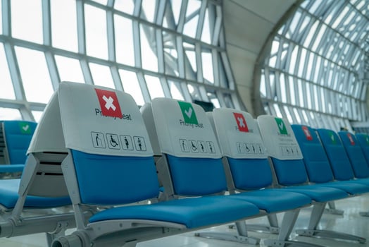 Empty seat in departure lounge at airport terminal. Distance for one seat keep distance to protect coronavirus and passenger social distancing for safety. Priority seating for people with disabilities photo