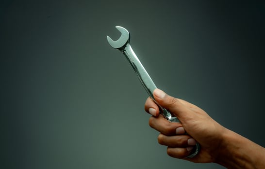 Technician hand holding chrome wrench. Plumber or mechanic technician work with spanner in hand. Mechanic tools. Service and maintenance machine in factory concept. Car or motorcycle fix or repair. photo