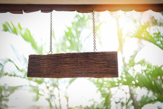 wooden sign hanging from roof - light wood rustic signboard on aged wooden wall photo