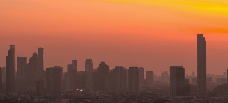 Air pollution. Smog and fine dust of pm2.5 covered city in the morning with orange sunrise sky. Cityscape with polluted air. Dirty environment. Urban toxic dust. Unhealthy air. Urban unhealthy living. photo