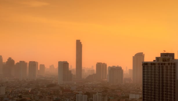 Air pollution in Bangkok, Thailand. Smog and fine dust of pm2.5 covered city in the morning with orange sunrise sky. Cityscape with polluted air. Dirty environment. Urban toxic dust. Unhealthy air. photo