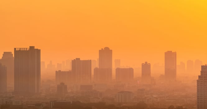 Air pollution. Smog and fine dust of pm2.5 covered city in the morning with orange sunrise sky. Cityscape with polluted air. Dirty environment. Urban toxic dust. Unhealthy air. Urban unhealthy living. photo