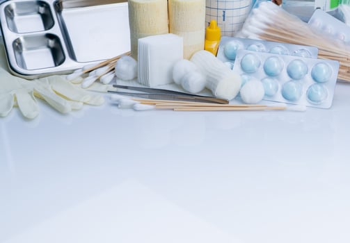 Wound care dressing set. Forceps, cotton stick, conform bandage, elastic cohesive retention bandage, cotton ball with alcohol, latex disposable gloves, and povidone-iodine. Medical supply for nurses. photo
