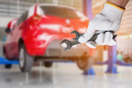Car mechanic holding wrench at the car repair garage photo
