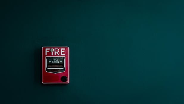 Fire alarm on dark green concrete wall. Warning and security system. Emergency equipment for safety alert. Red box of fire alarm on wall of school, hospital, factory, office, apartment, or home. photo
