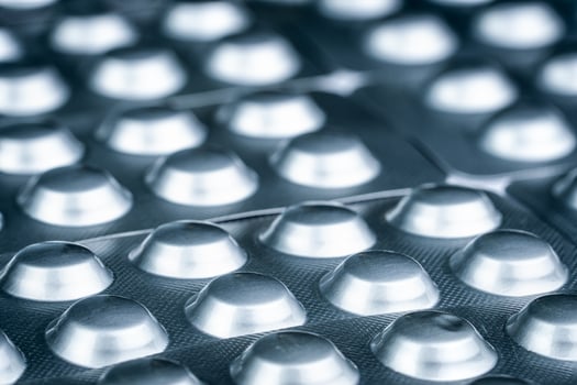 Tablets pill in silver aluminium foil blister pack. Pharmaceutical industry.  Many of blister packaging of pills with light. Medication for treatment illness.  Pharmacology and pharmaceutics concept. photo