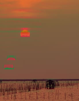 Beautiful sunset sky over the sea in the evening. The sun is obscured by some clouds at sunset. Fisher man hut of coastal fishing in Thailand. Sea at dusk. Silhouette seascape and hut at coastal. photo