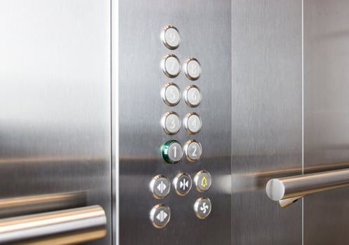 Buttons and handrail in metal elevator photo