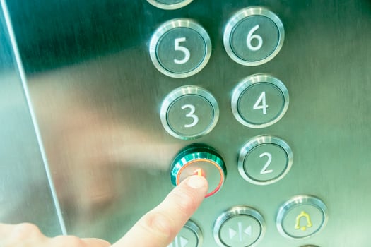 Man's hand causes first floor in metal elevator photo