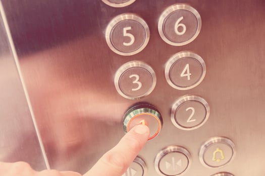 Man's hand causes first floor in metal elevator photo