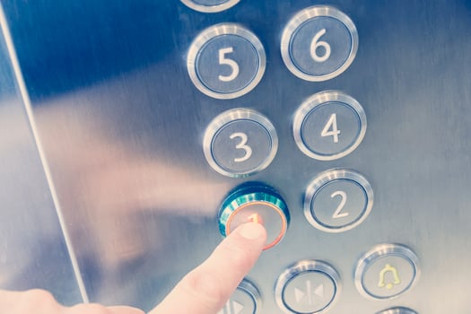 Man's hand causes first floor in metal elevator photo
