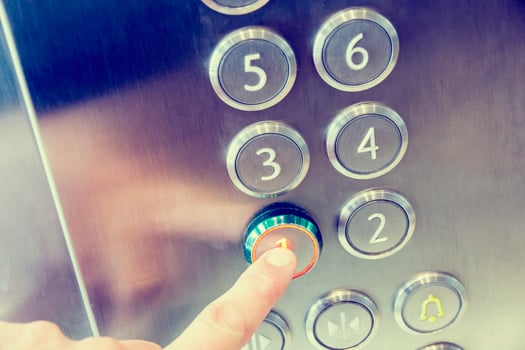 Man's hand causes first floor in metal elevator photo