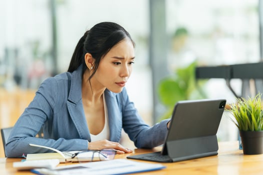 Portrait of Asian young female working on laptop and financial report at office. photo
