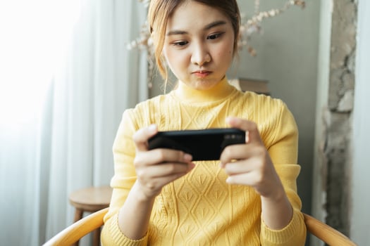 Asian woman excited while playing mobile games, reading good news while surfing the internet world. photo