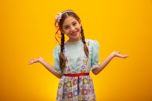 Child in typical clothes of famous Brazilian party called Festa Junina in celebration of Sao Joao. Beautiful girl on yellow background. photo