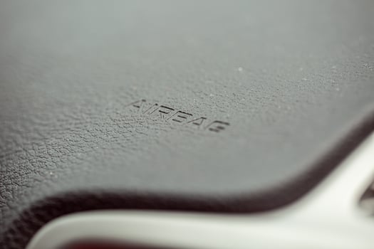 Inscription on the panel of the vehicle airbag. background of grey textured plastic close-up photo