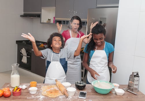 Mother and children preparing lunch together in the kitchen. Messy children. photo