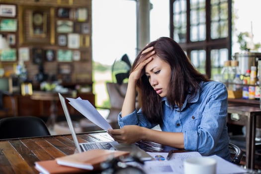 Young woman sitting in a cafe with her laptop, Stressful for work. photo