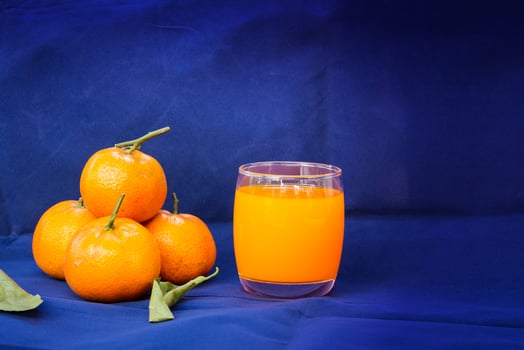 Glasses of orange juice and fruits with dried leaves photo