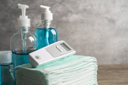 Blue alcohol sanitizer gel with digital thermometer and mask for new normal protect covid19 coronavirus pandemic. photo