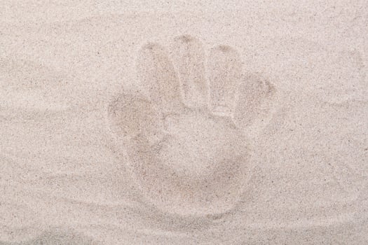 Palm footprint in the sand top view. Sand copy space. Sand background top view. photo